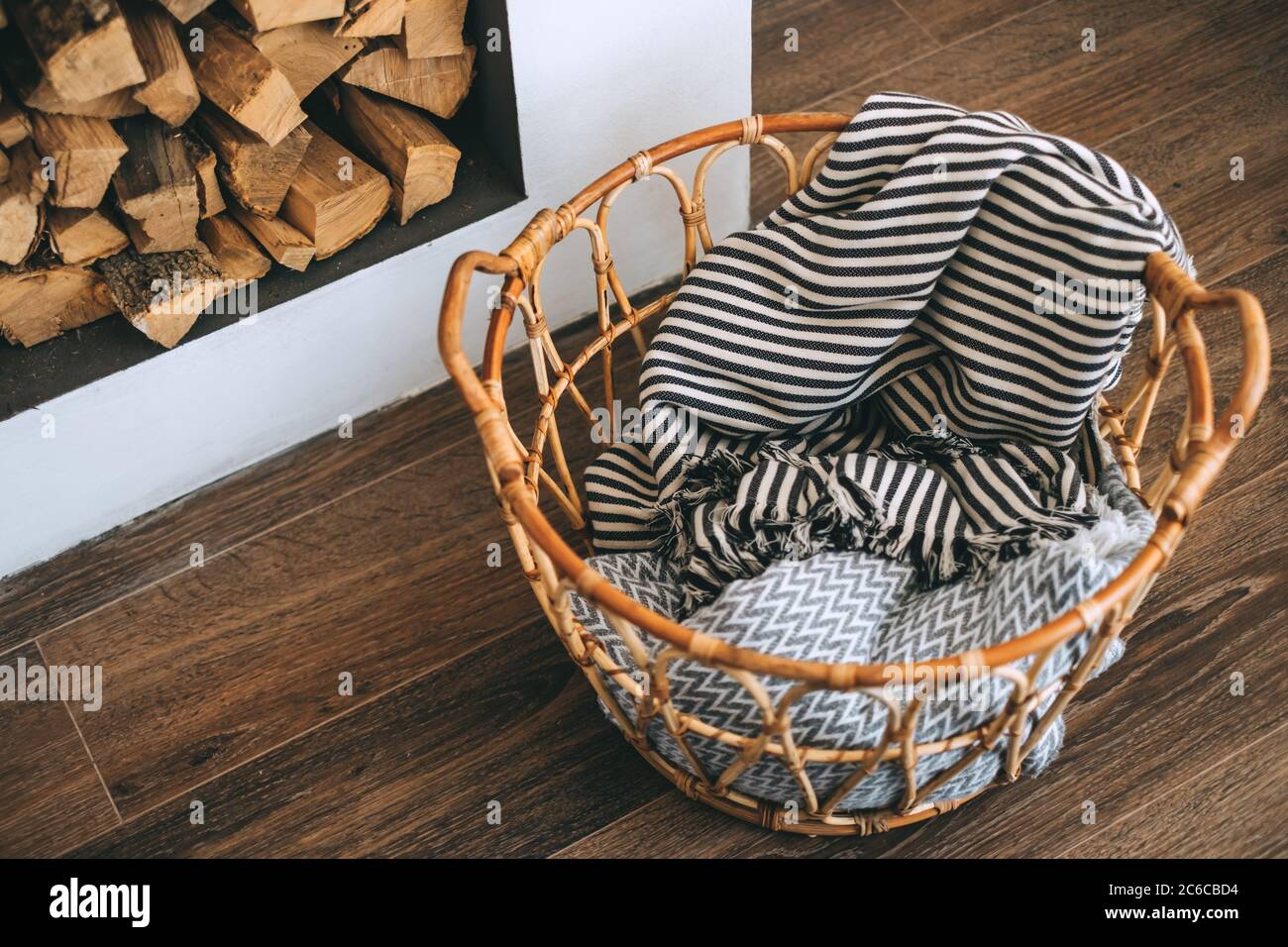 View of Wooden wicker basket with plaids in a living room, interior details ...