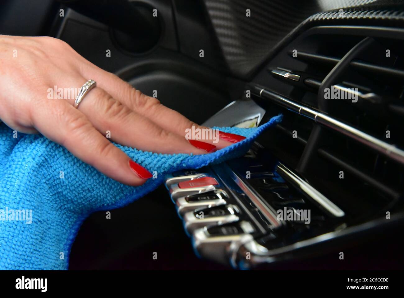 Cleaning the car console with a microfiber cloth. Woman's hand hand ...
