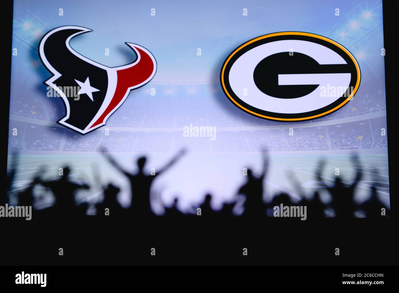 Houston Texans vs. Green Bay Packers Fans support on NFL Game. Silhouette of supporters, big screen with two rivals in background. Stock Photo