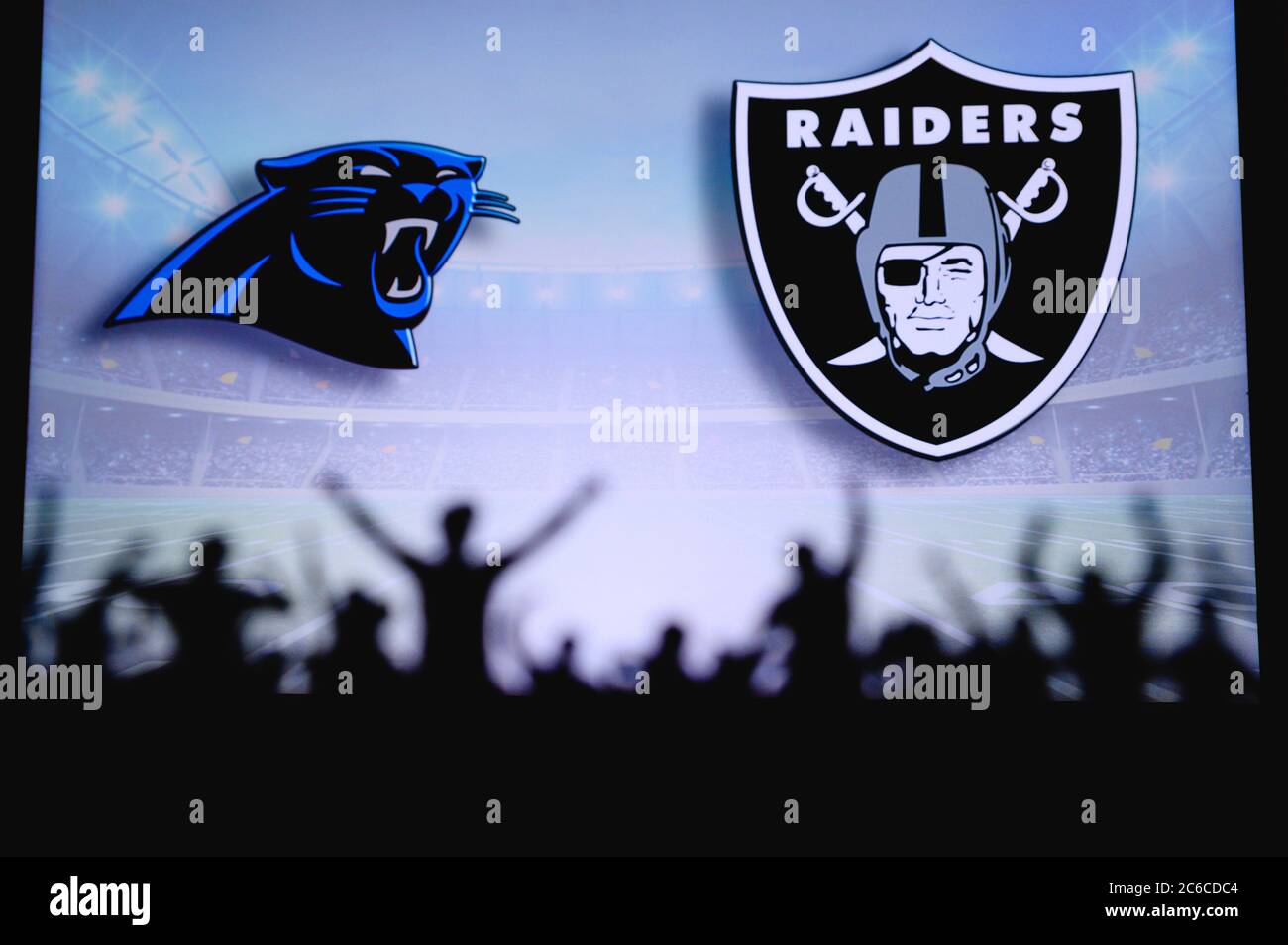 Carolina Panthers vs. Las Vegas Raiders. Fans support on NFL Game. Silhouette of supporters, big screen with two rivals in background. Stock Photo