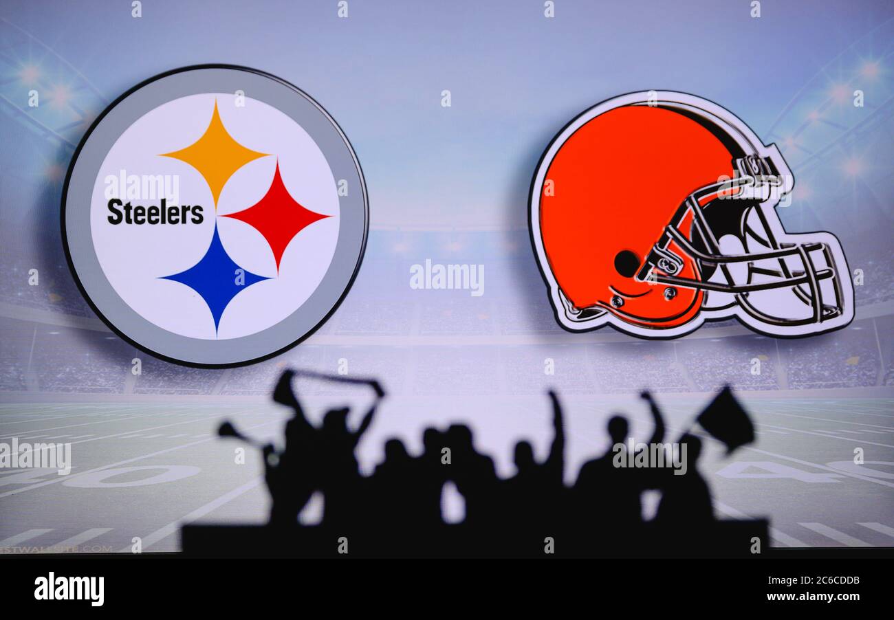 Pittsburgh Steelers vs. Cleveland Browns. Fans support on NFL Game. Silhouette of supporters, big screen with two rivals in background. Stock Photo