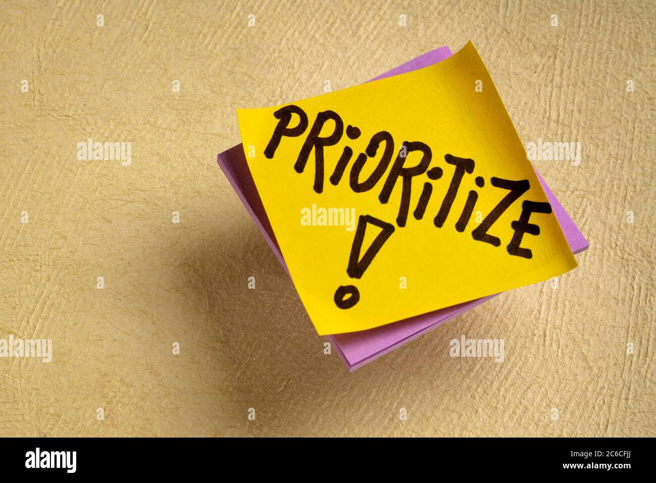 prioritize advice or reminder - handwriting on a sticky note, personal life or business productivity and efficiency concept Stock Photo
