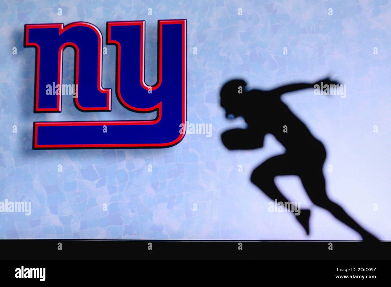 New York Giants. Silhouette of professional american football player. Logo of NFL club in background, edit space. Stock Photo