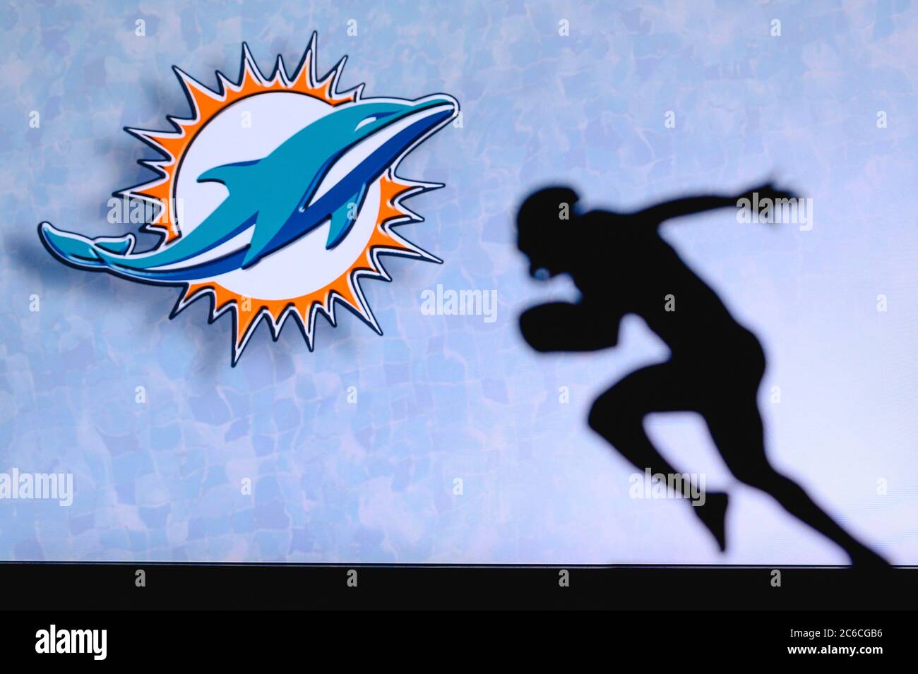 Miami Dolphins. Silhouette of professional american football player. Logo of NFL club in background, edit space. Stock Photo