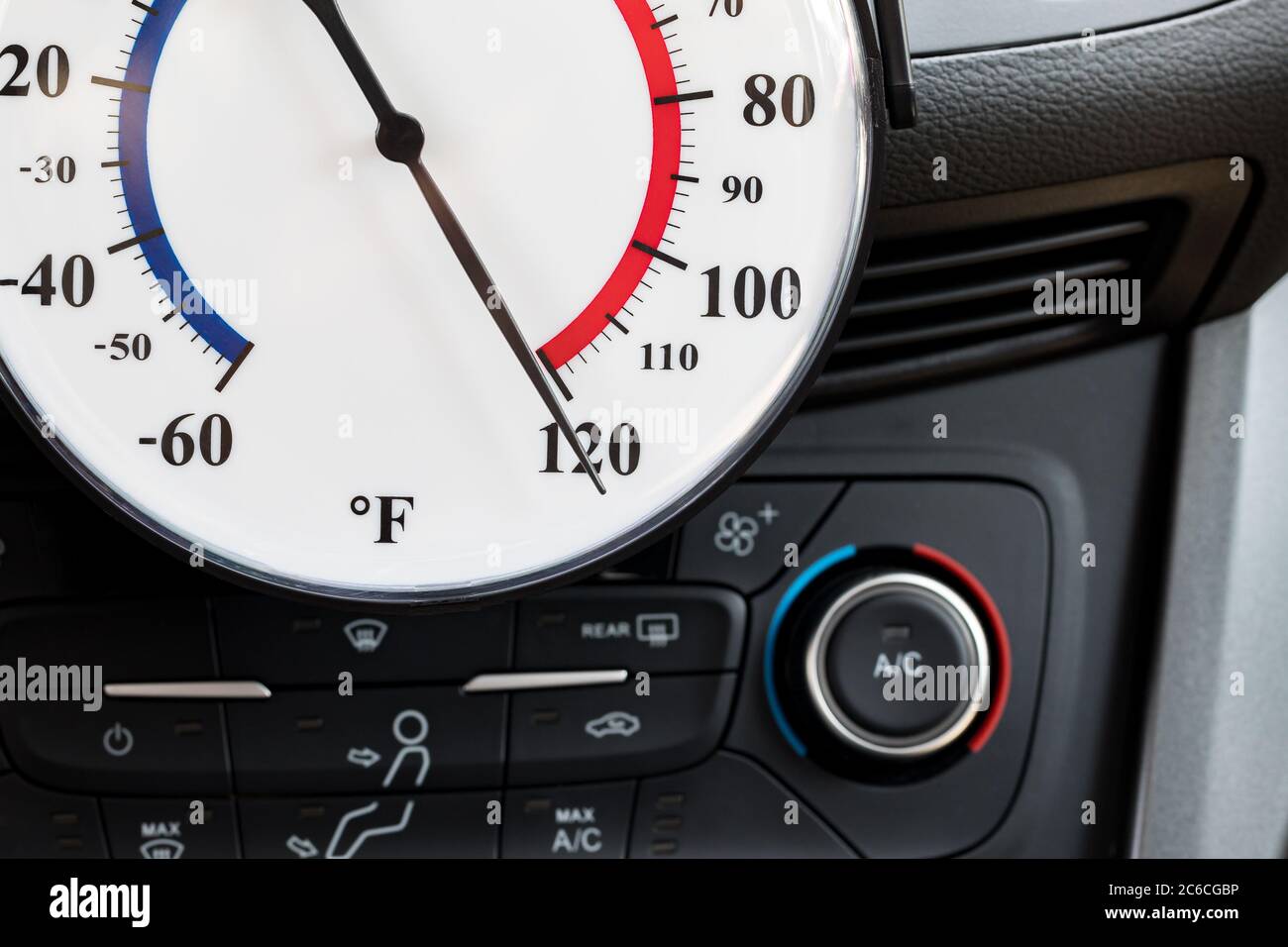 Thermometer inside parked car during summer heat wave. Concept of dangerous and deadly temperature, child and pet danger and safety precautions Stock Photo