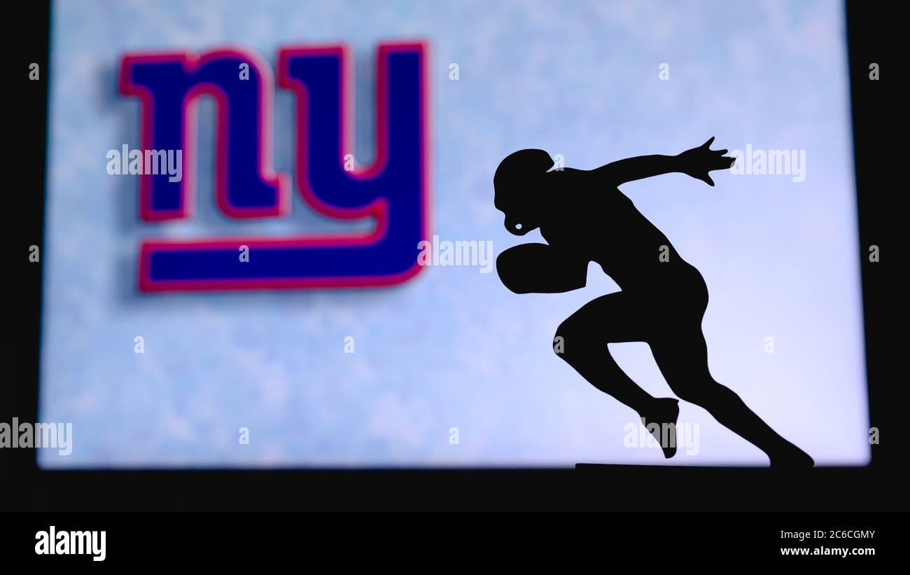 New York Giants. Silhouette of professional american football player. Logo of NFL club in background, edit space. Stock Photo