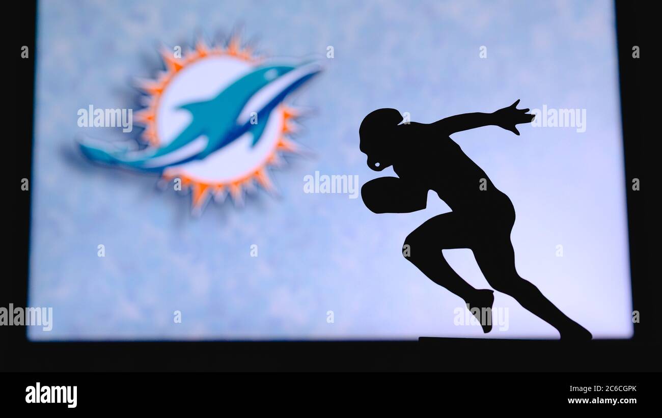 Miami Dolphins. Silhouette of professional american football player. Logo of NFL club in background, edit space. Stock Photo