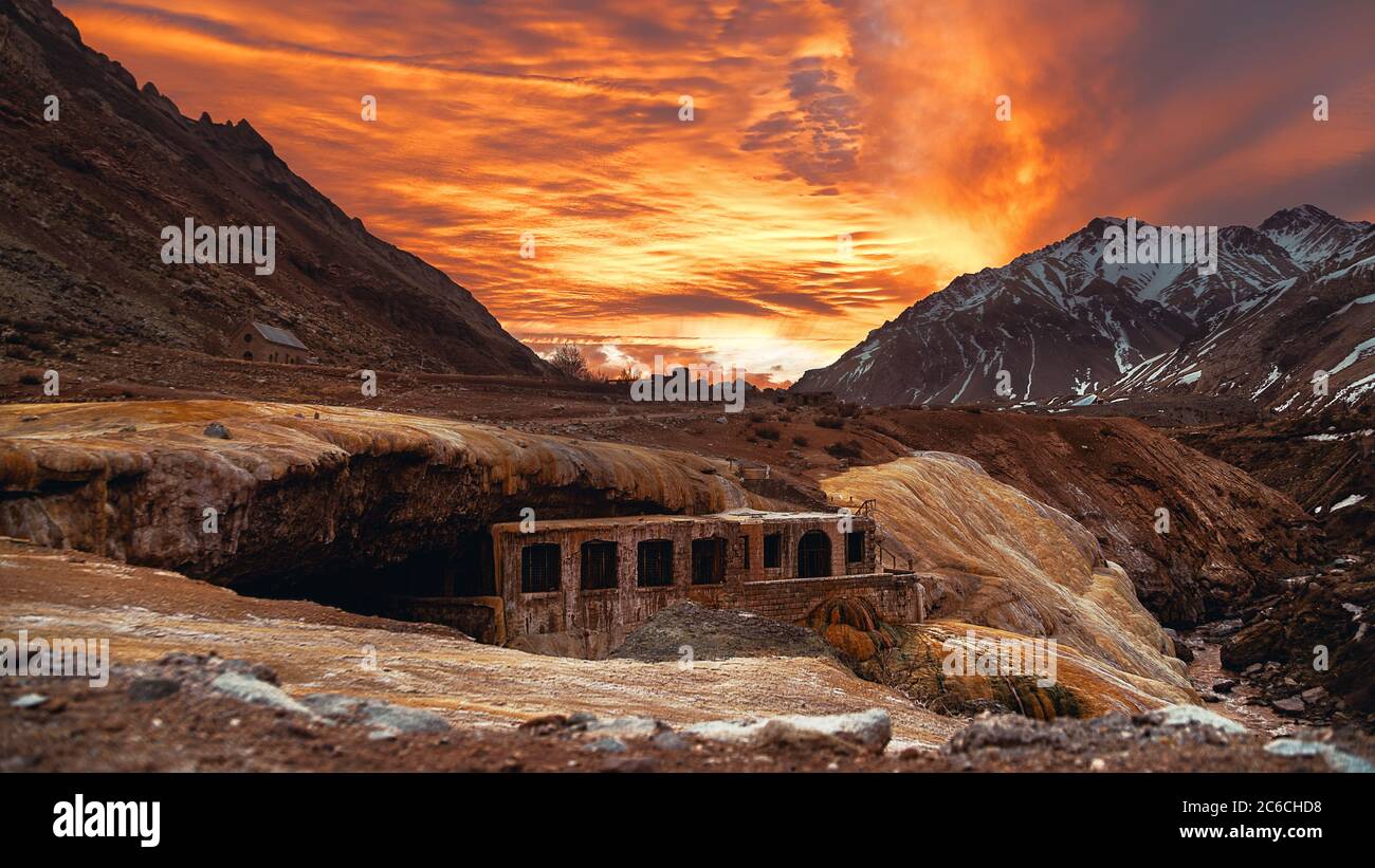 Amazing sunset with the view of the Inca Bridge where there are a lot of warm colors with the Andes Mountains on the bottom Stock Photo