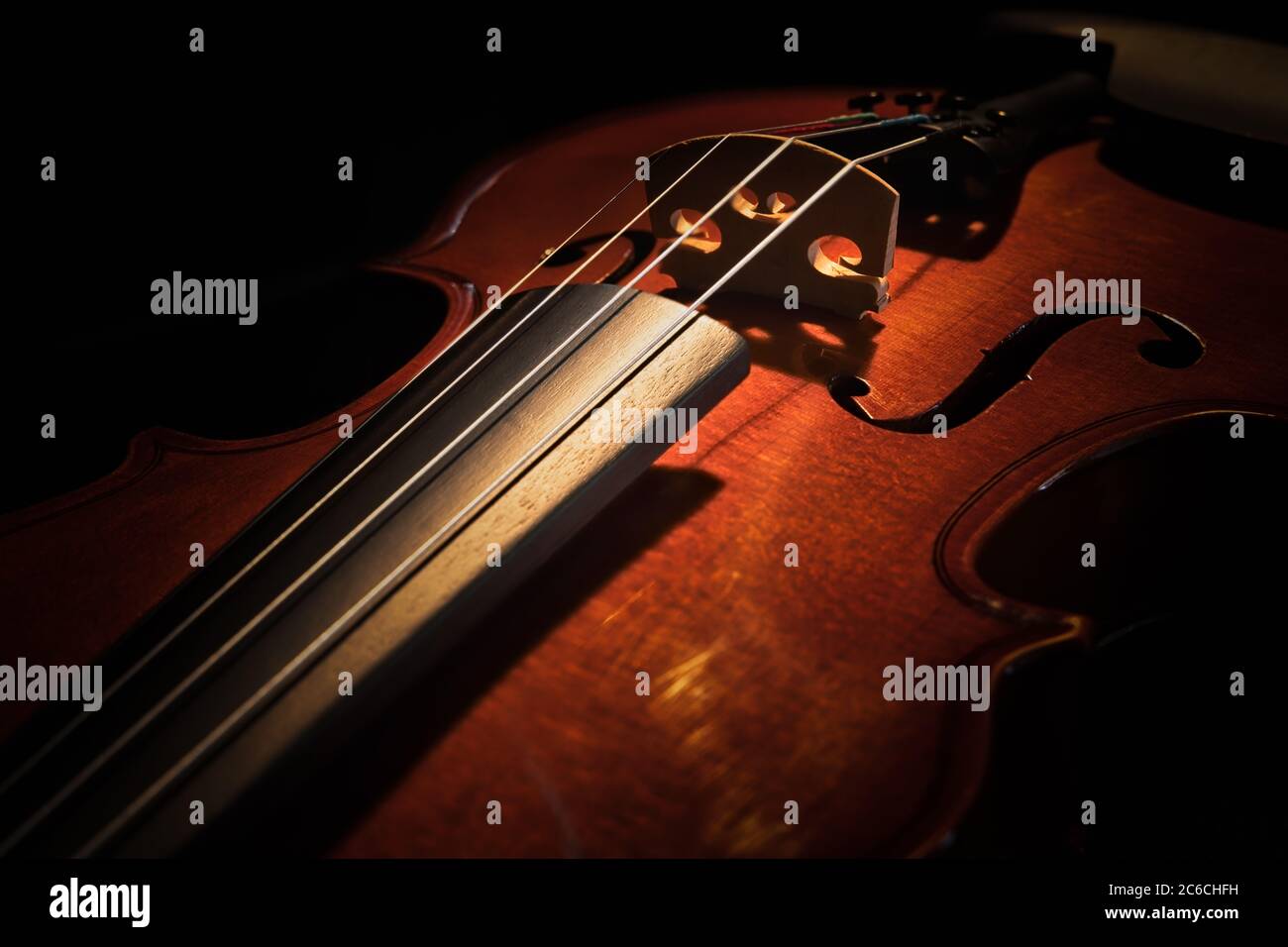A violin sitting on a chair with soft lighting. Stock Photo