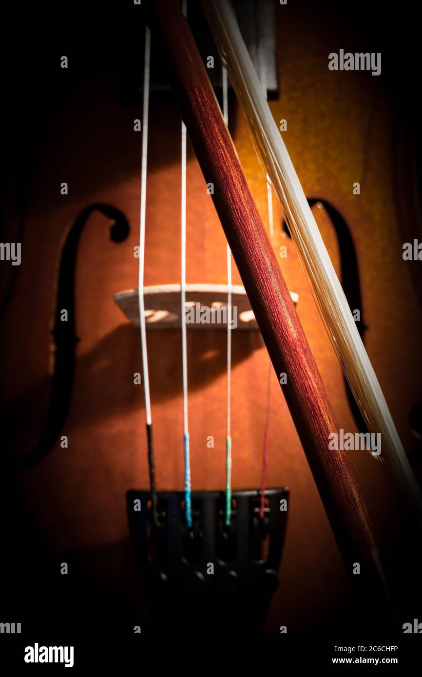 A violin sitting on a chair with soft lighting. Stock Photo