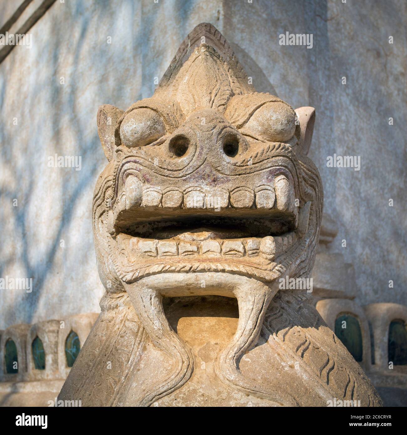 A close-up view of a carved stone statue of a chinthe (lion) at the Ananda Buddhist Temple in Yangon, Myanmar Stock Photo