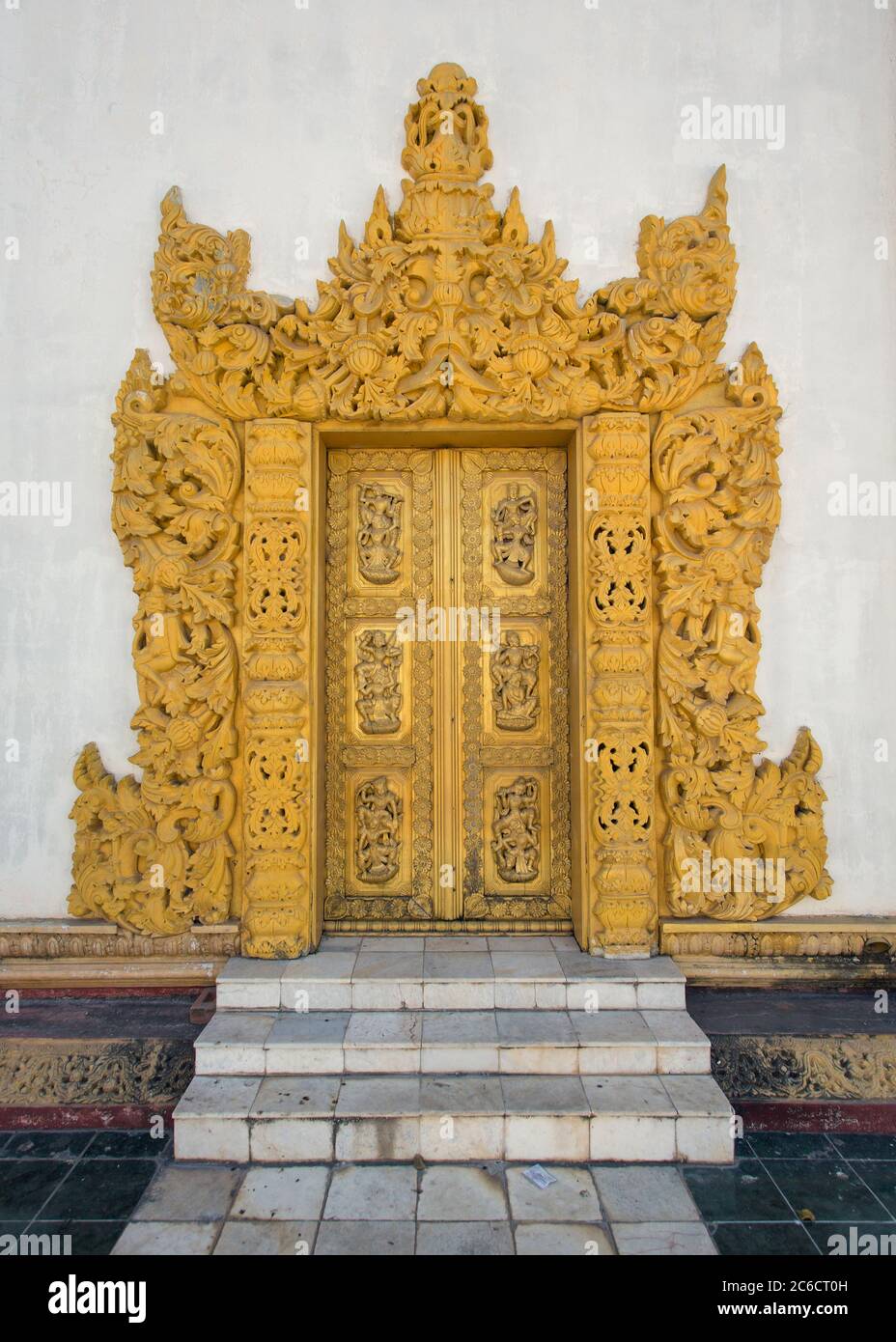 An exterior view of an intricately carved and gilded wooden door of an ancient temple in Bagan, Myanmar Stock Photo