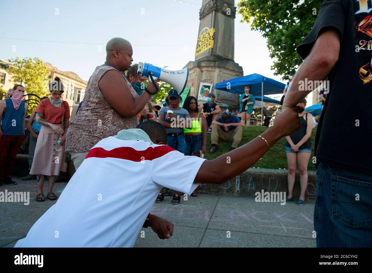 Bloomington, Indiana, USA. 7th June, 2020. Reverend Angela Carter, left, says some words for Big Mike (Michael Parker) during a vigil for BLM activist Big Mike (Michael Parker), who was shot and killed early Sunday. Parker had been at the Monroe County Square to protest against the killing of George Floyd, and said he was going to a convenience store to get supplies for the protest, but was shot and killed during an apparent robbery. The protesters heard the shots several blocks away. Credit: Jeremy Hogan/SOPA Images/ZUMA Wire/Alamy Live News Stock Photo