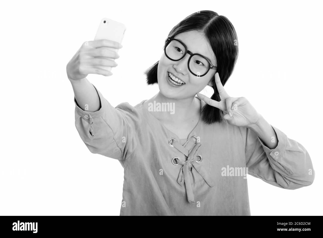 Young happy Asian woman smiling while taking selfie picture with mobile ...
