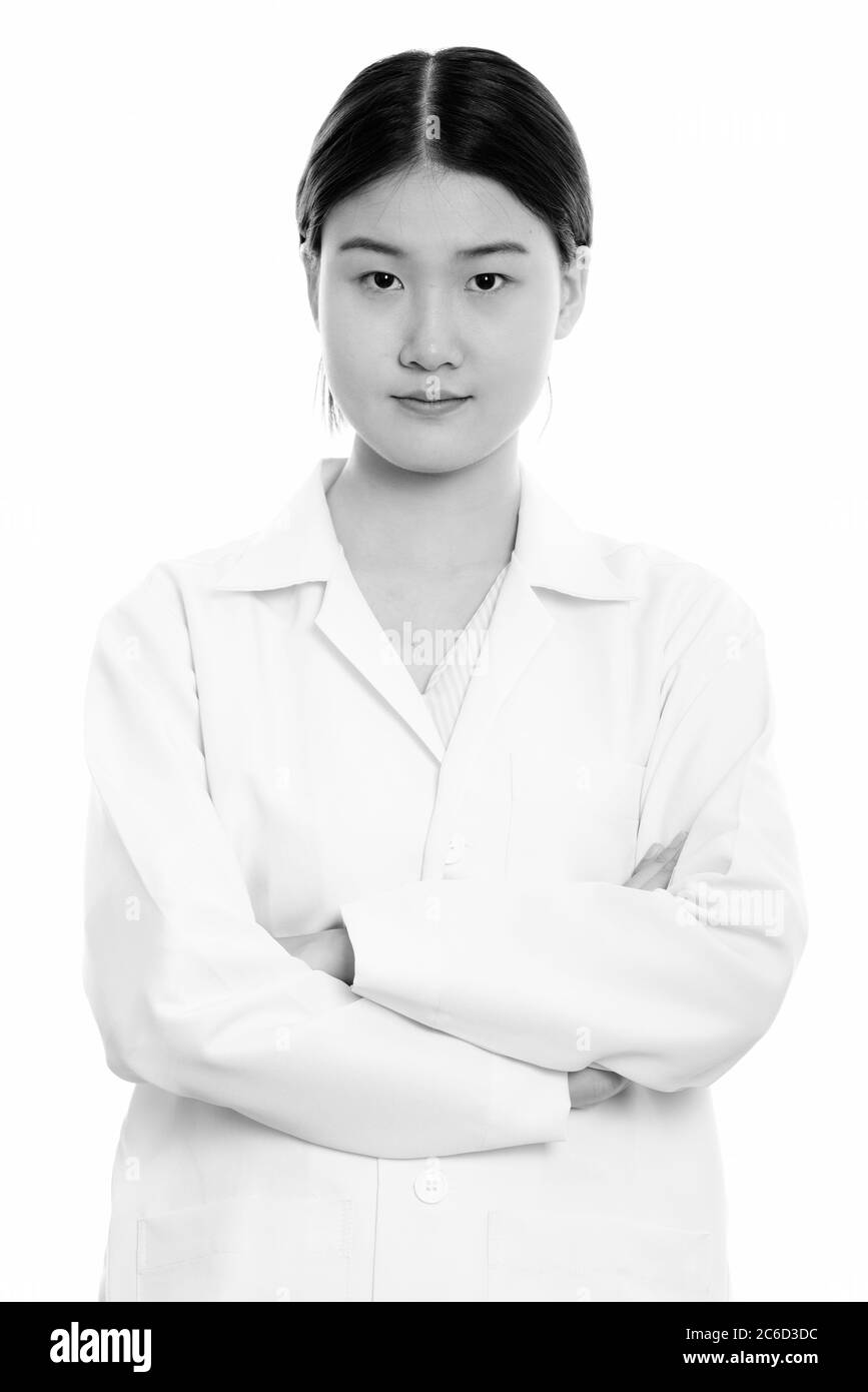 Studio shot of young beautiful Asian woman doctor with arms crossed ...