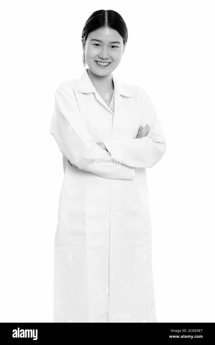 Young happy Asian woman doctor smiling and standing with arms crossed ...