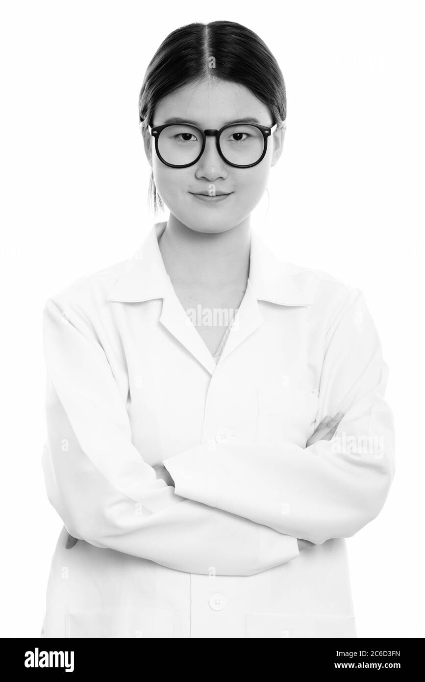 Studio shot of young beautiful Asian woman doctor with arms crossed ...