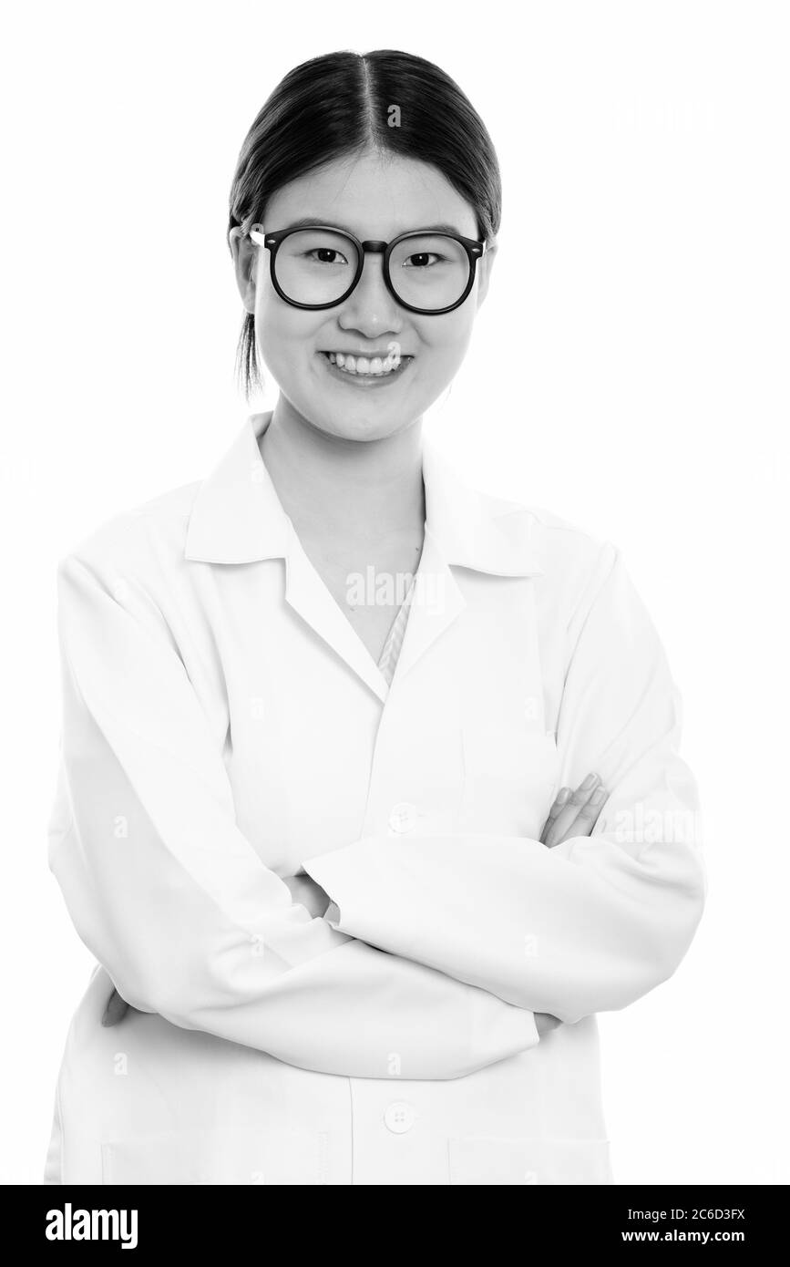 Studio shot of young happy Asian woman doctor smiling with arms crossed ...
