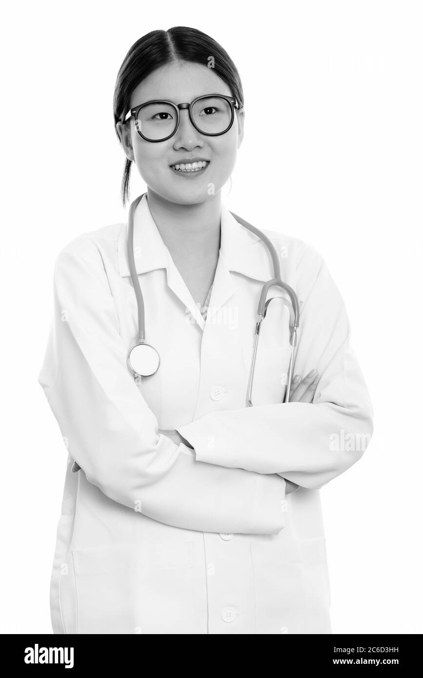 Studio shot of young happy Asian woman doctor smiling and thinking with ...