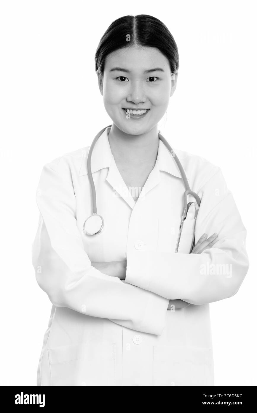 Studio shot of young happy Asian woman doctor smiling with arms crossed ...