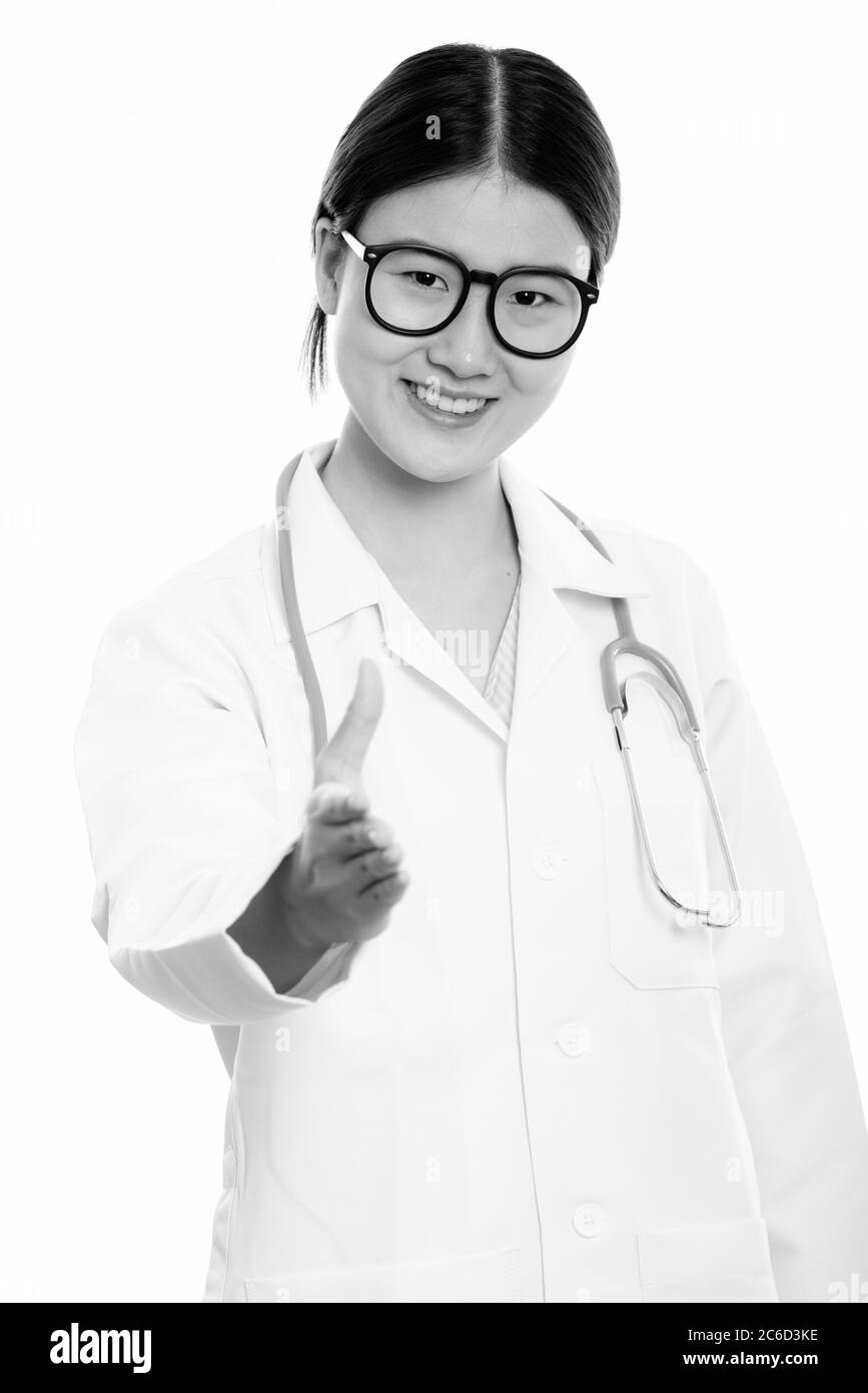 Studio shot of young happy Asian woman doctor smiling while giving ...
