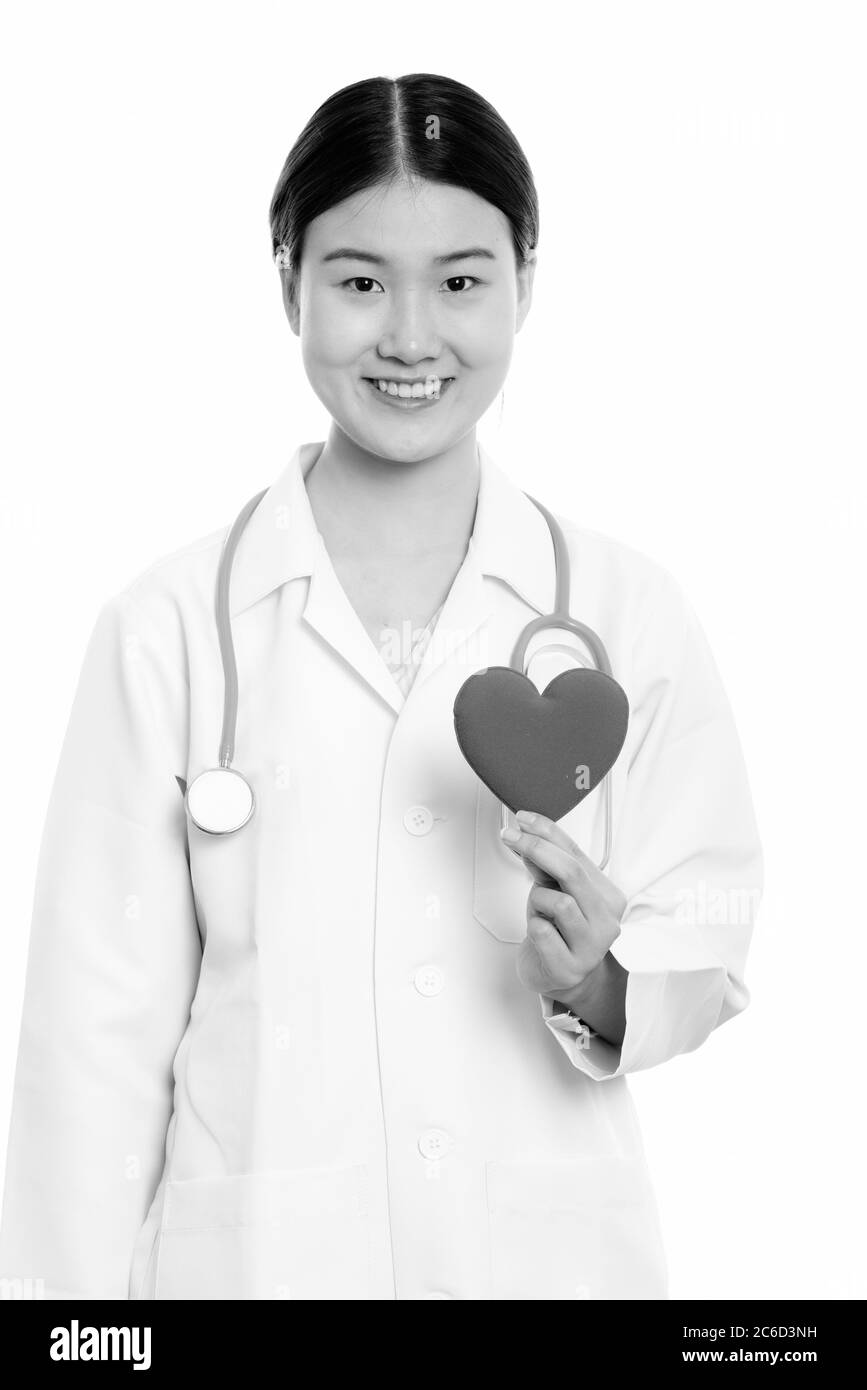 Young happy Asian woman doctor smiling while holding red heart Stock ...