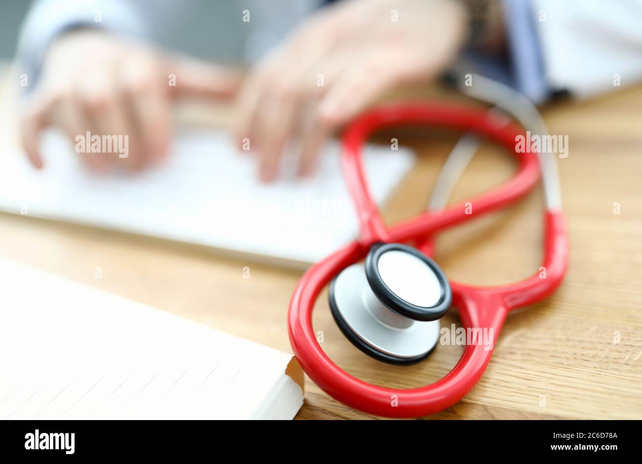 Red stethoscope is lying on table Stock Photo