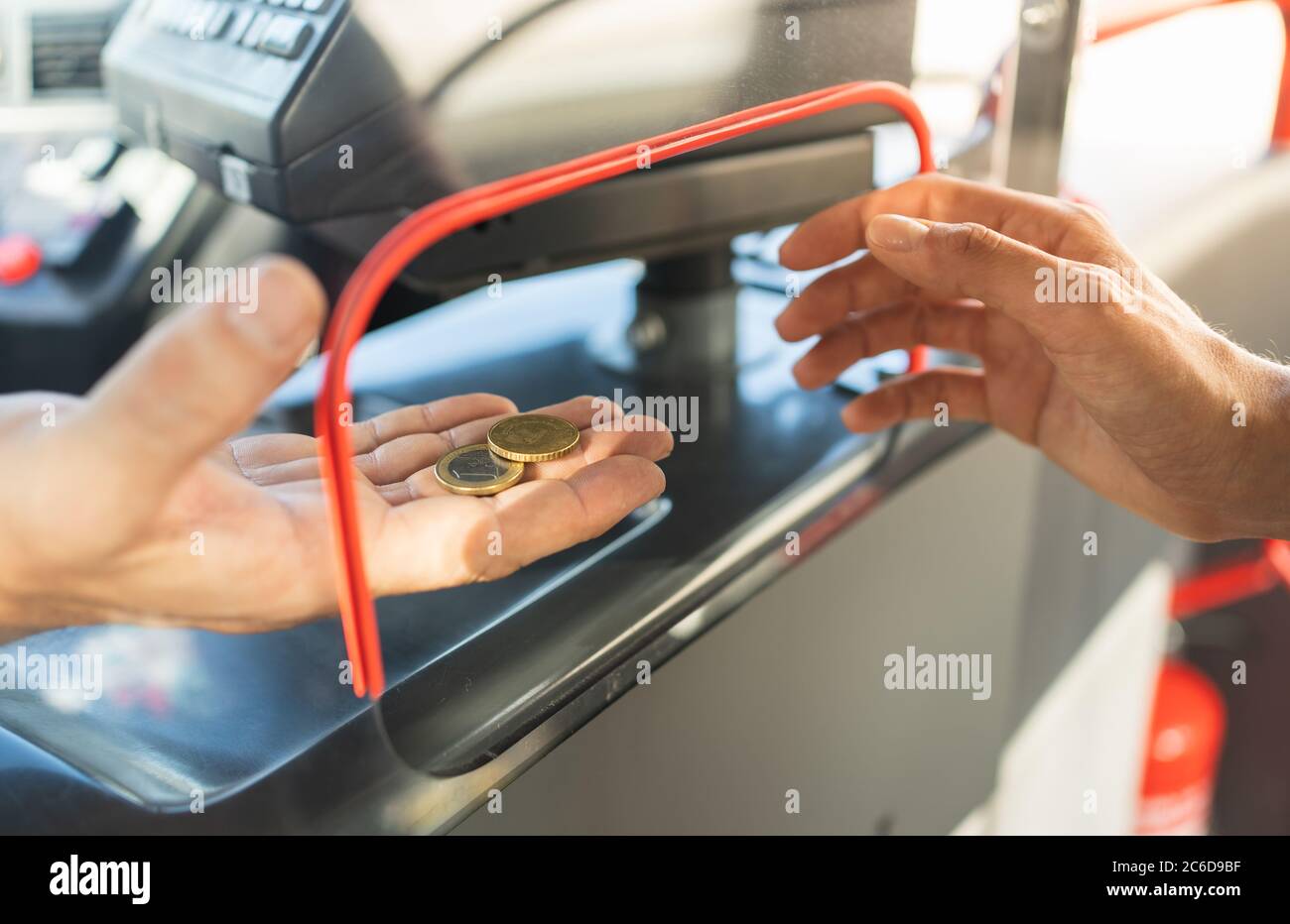 Selective focus on the hand of a bus driver taking the money from a