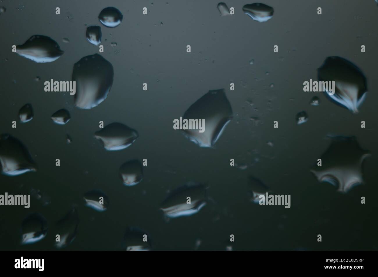 Rain drops on window glasses surface with cloudy background . Natural