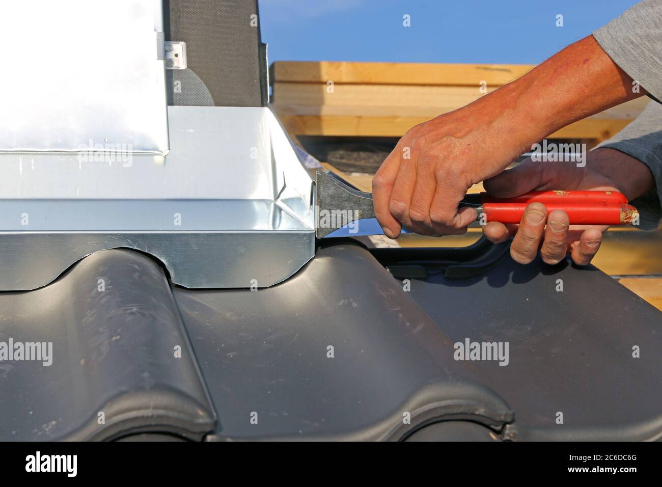 Roofer working on exterior chimney cladding Stock Photo