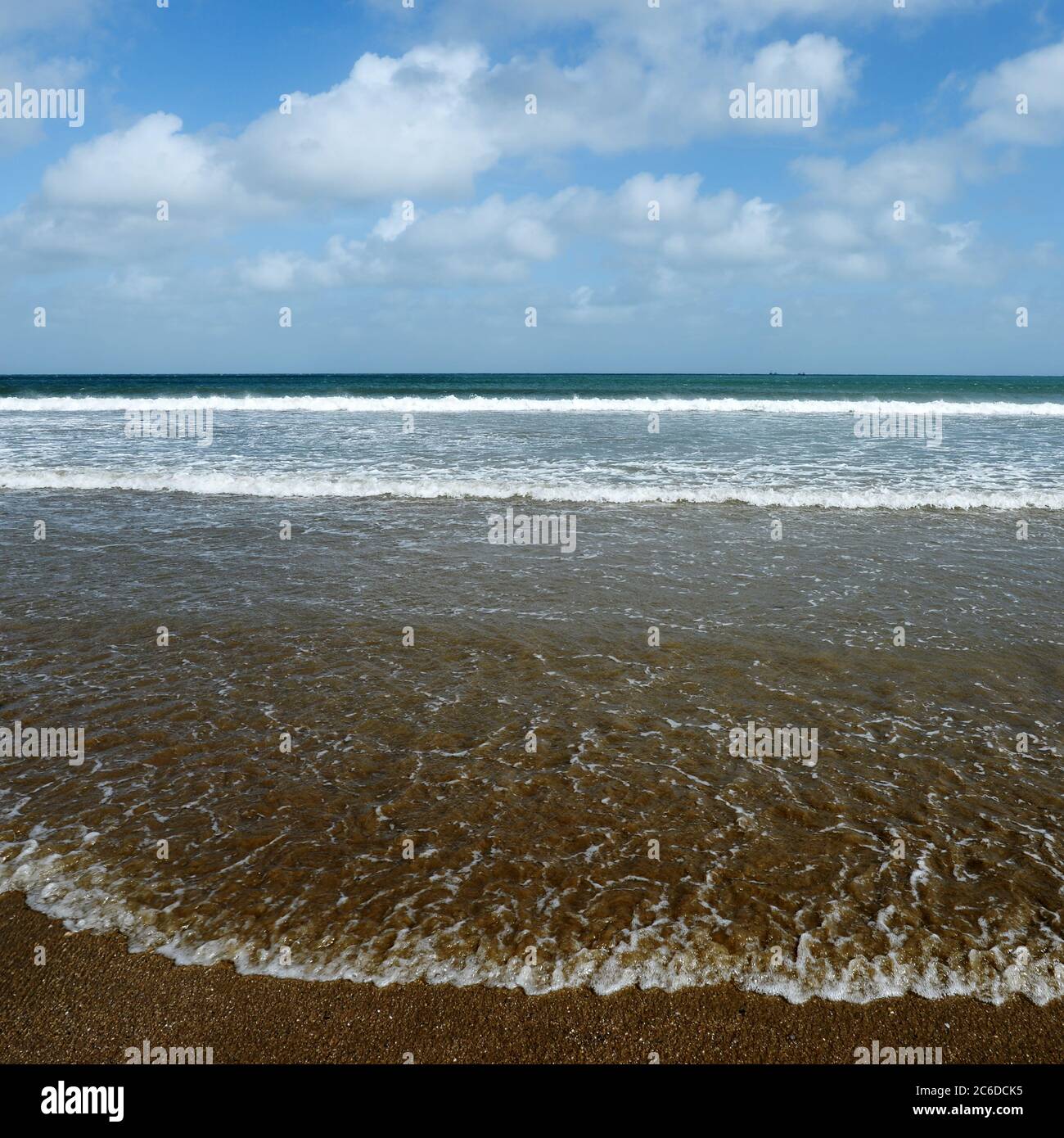 The Beach -where land meets sky and sea and waves lap the edges Stock Photo