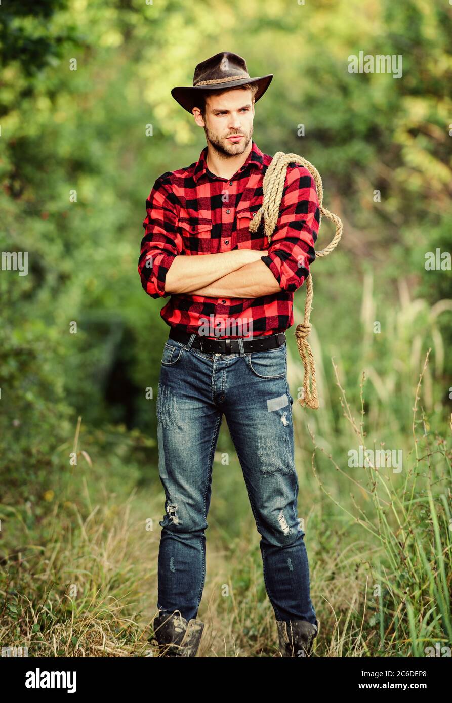 Cowboys are gentlemen. wild west rodeo. man in hat outdoor. man checkered  shirt on ranch. Vintage style man. Wild West retro cowboy. cowboy with  lasso rope. Western. western cowboy portrait Stock Photo -