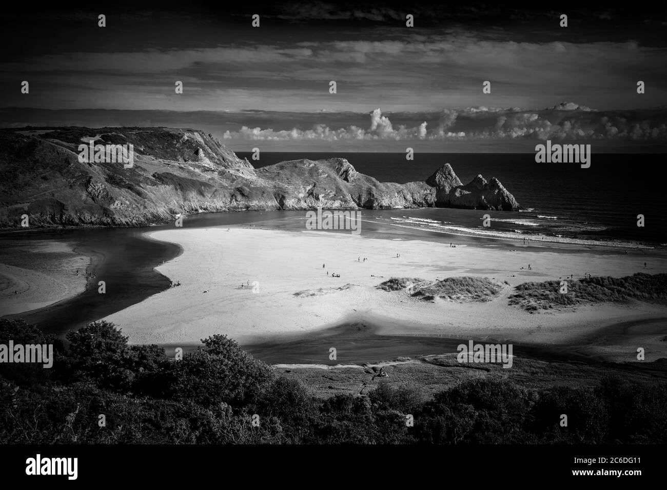 Three Cliffs Bay on the Gower Peninsular West Glamorgan Wales UK which is a popular Welsh coastline attraction of outstanding beauty monochrome image Stock Photo