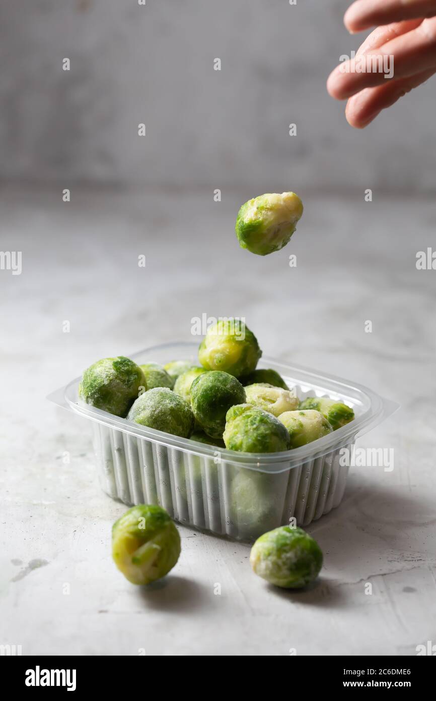 Frozen falling Brussels sprouts in the storage boxes on the kitchen