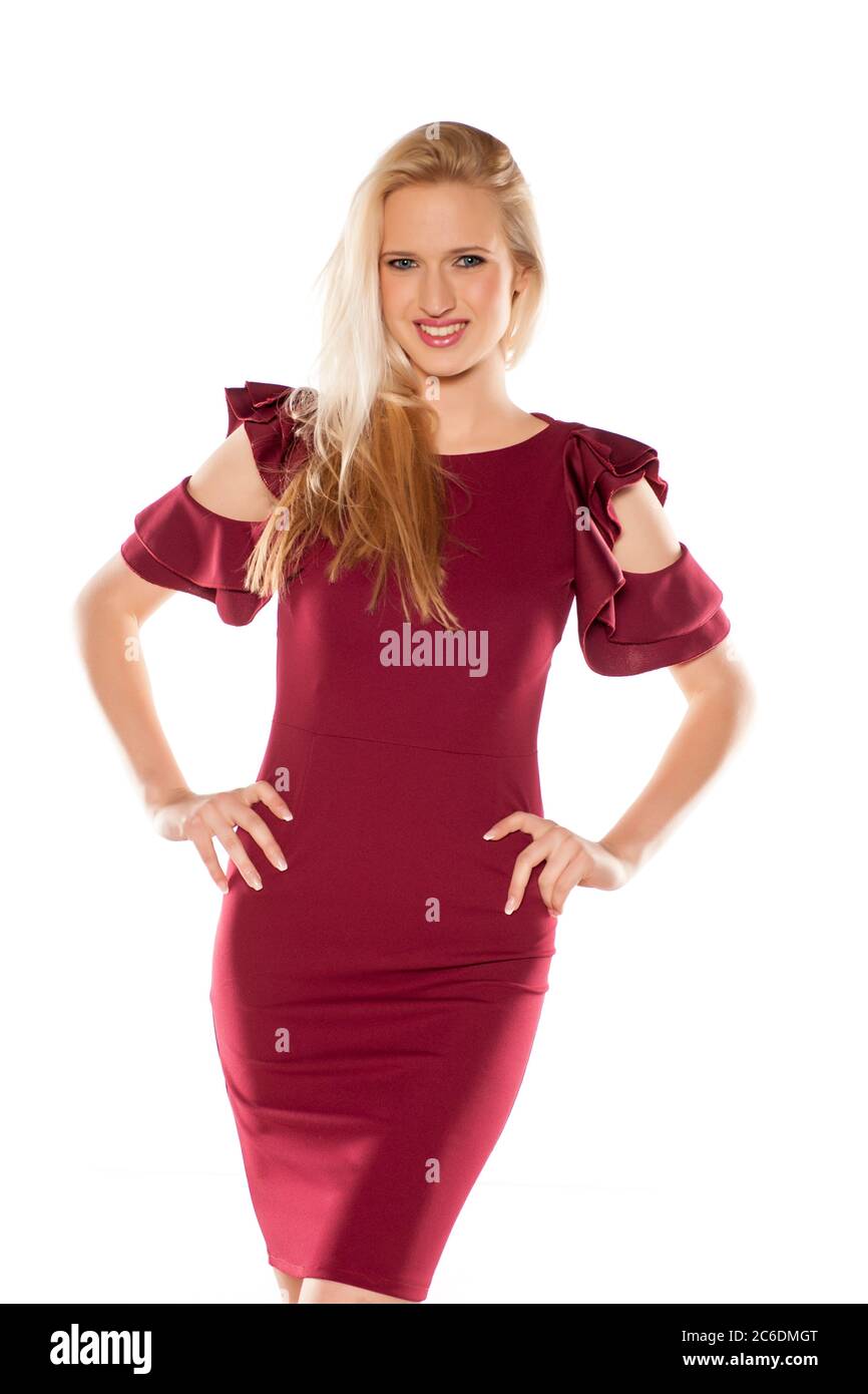 blonde in burgundy dress attractive smiling blonde in a short burgundy dress on white background  Stock Photo