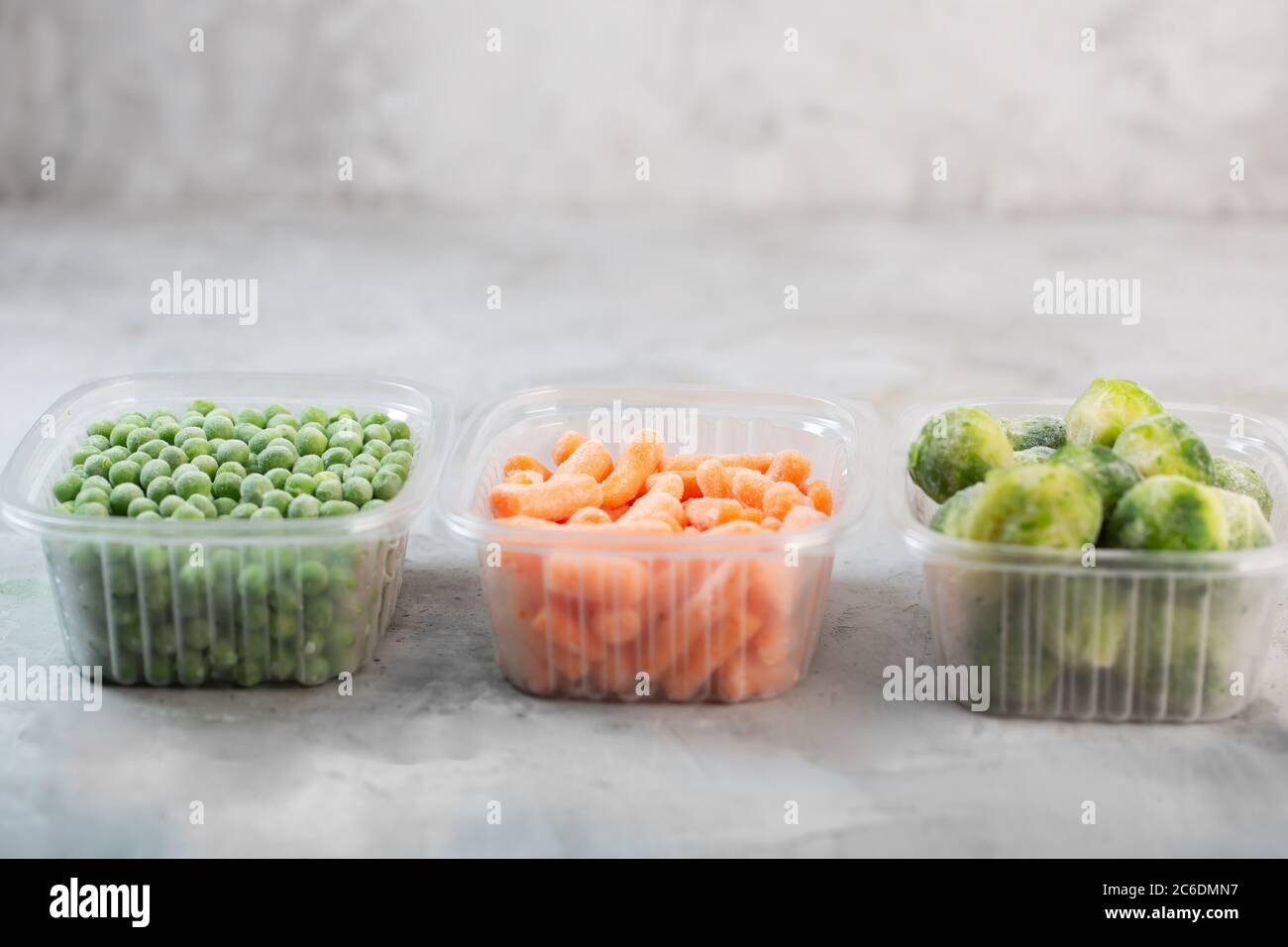 Frozen vegetables such as green peas, brussels sprouts and baby carrot in the storage boxes on