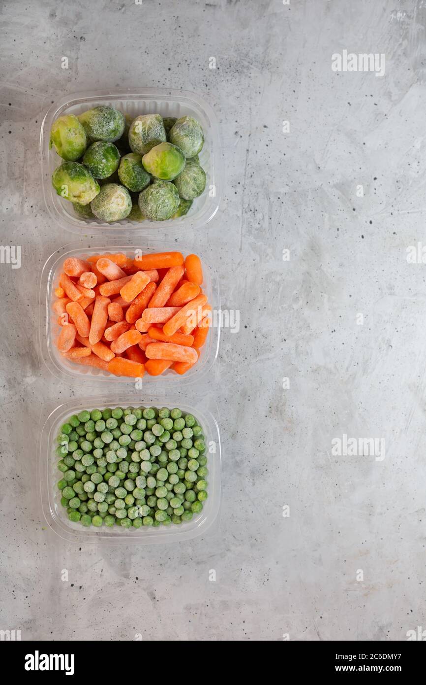 Frozen vegetables such as green peas, brussels sprouts and baby carrot in the storage boxes on