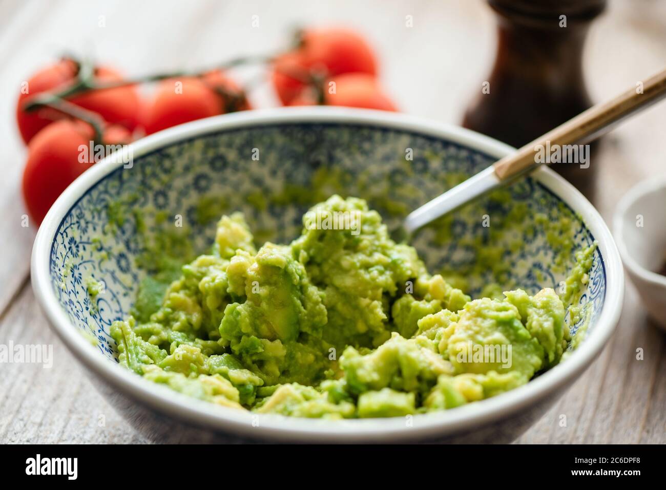 Mashed avocado in a bowl. Guacamole sauce, avocado mash. Closeup view, selective focus Stock Photo