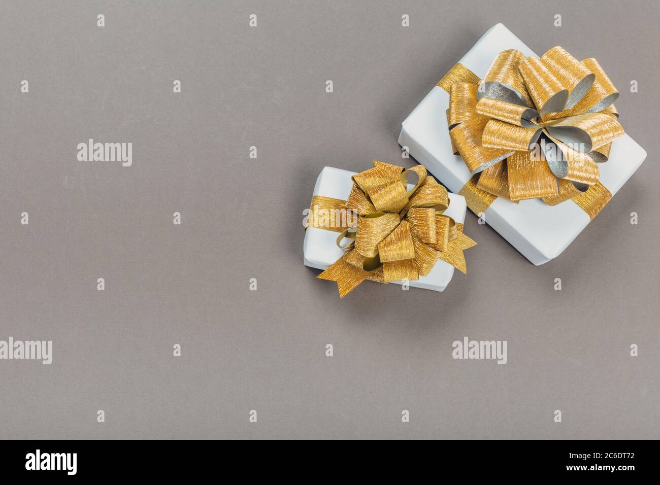 beautiful gift box wrapped in paper with a gold ribbon and a bow on a ...