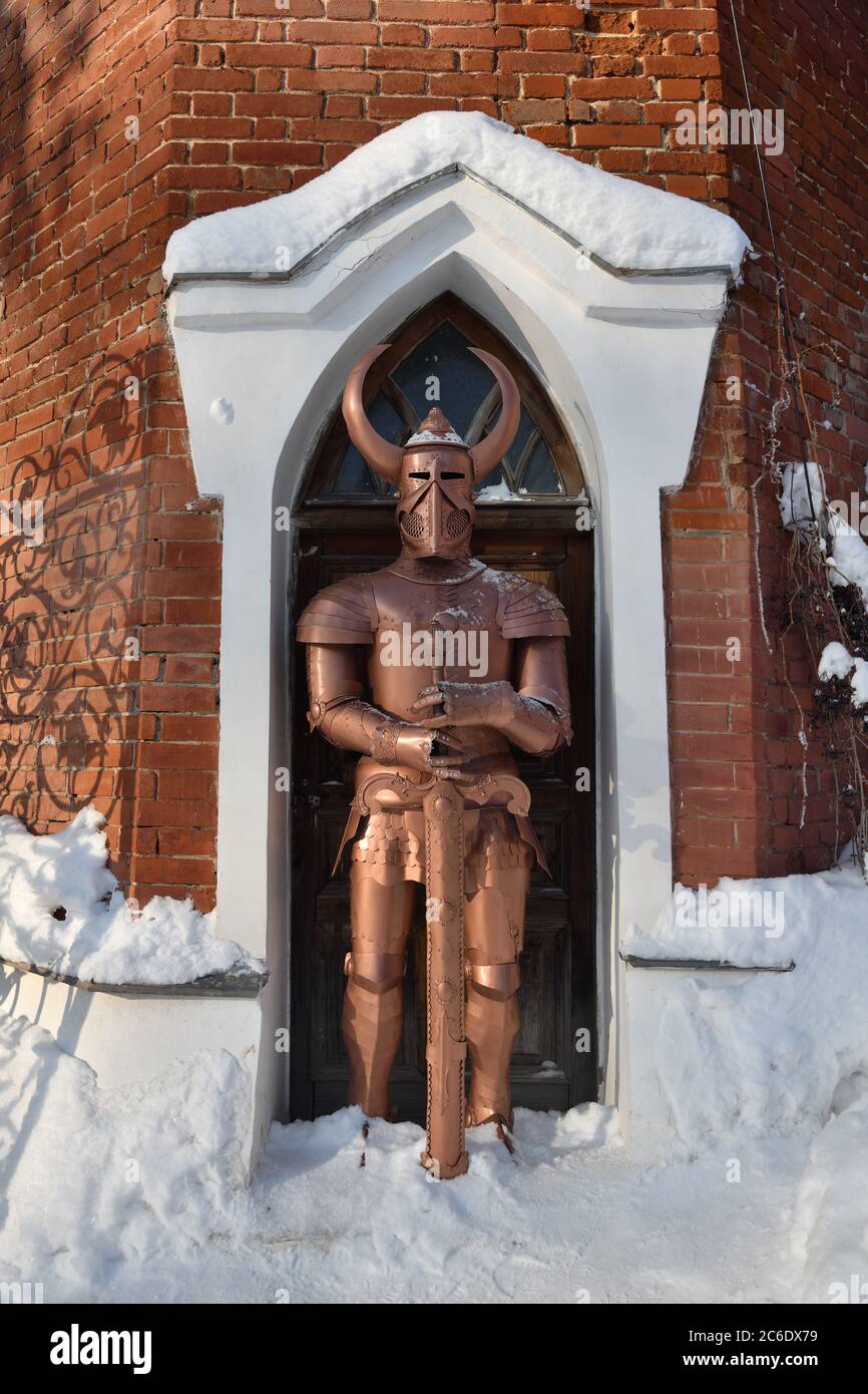 Knight armor with sword guards the gates at winter. Modern replica Stock Photo