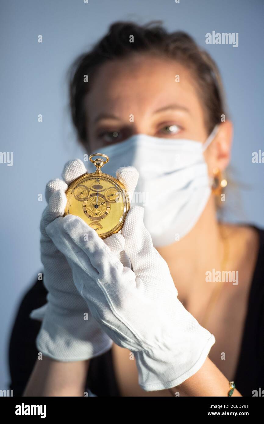 A Sotheby's employee holds King George III's Tourbillion watch which is on show at Sotheby's in central London ahead of its sale by the auction house during their Collection of a Connoisseur auction on July 4. Stock Photo