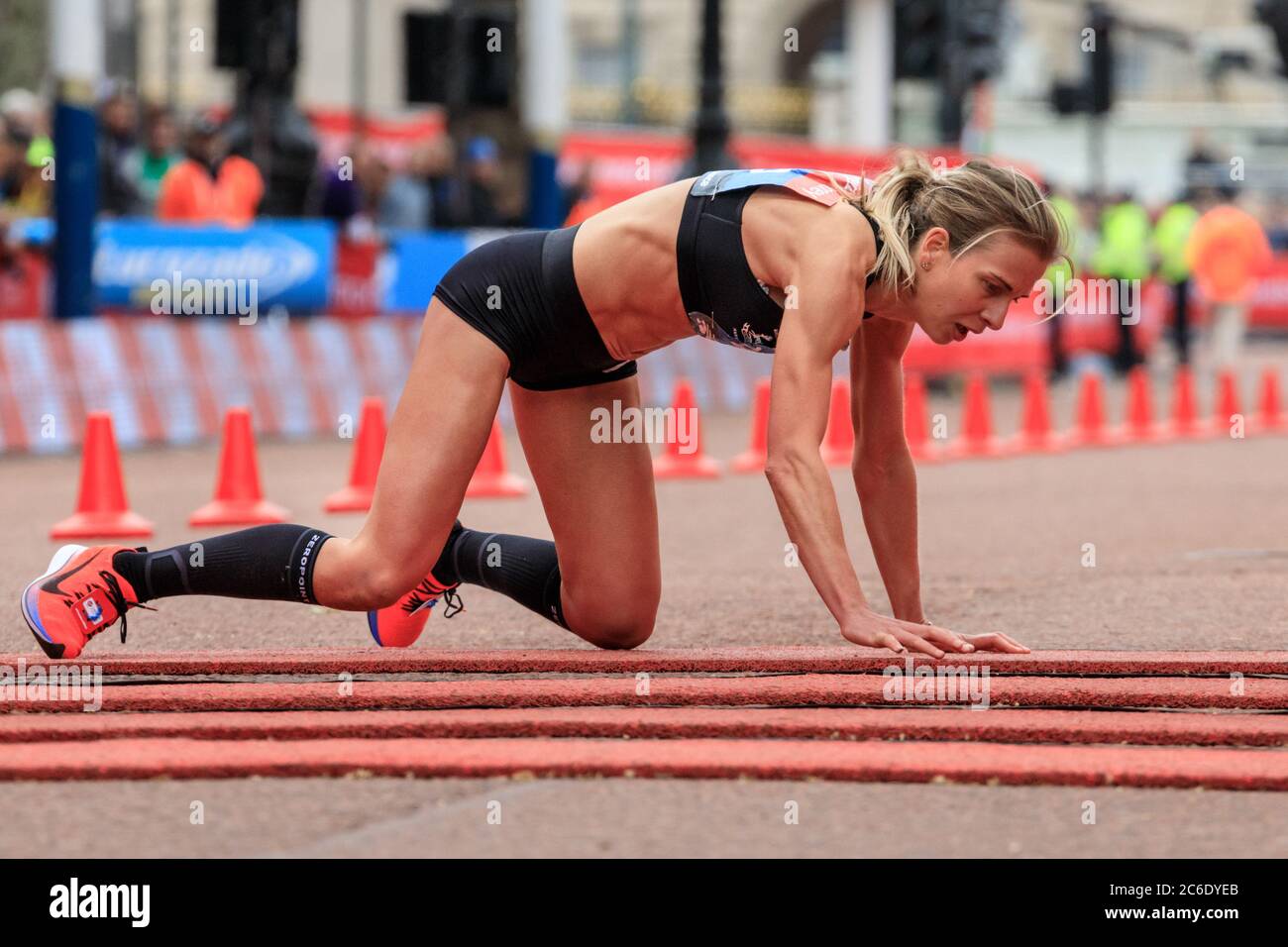 Female British elite runner Hayley Carruthers crawls over the finish line at Virgin Money London Marathon 2019, England, UK Stock Photo