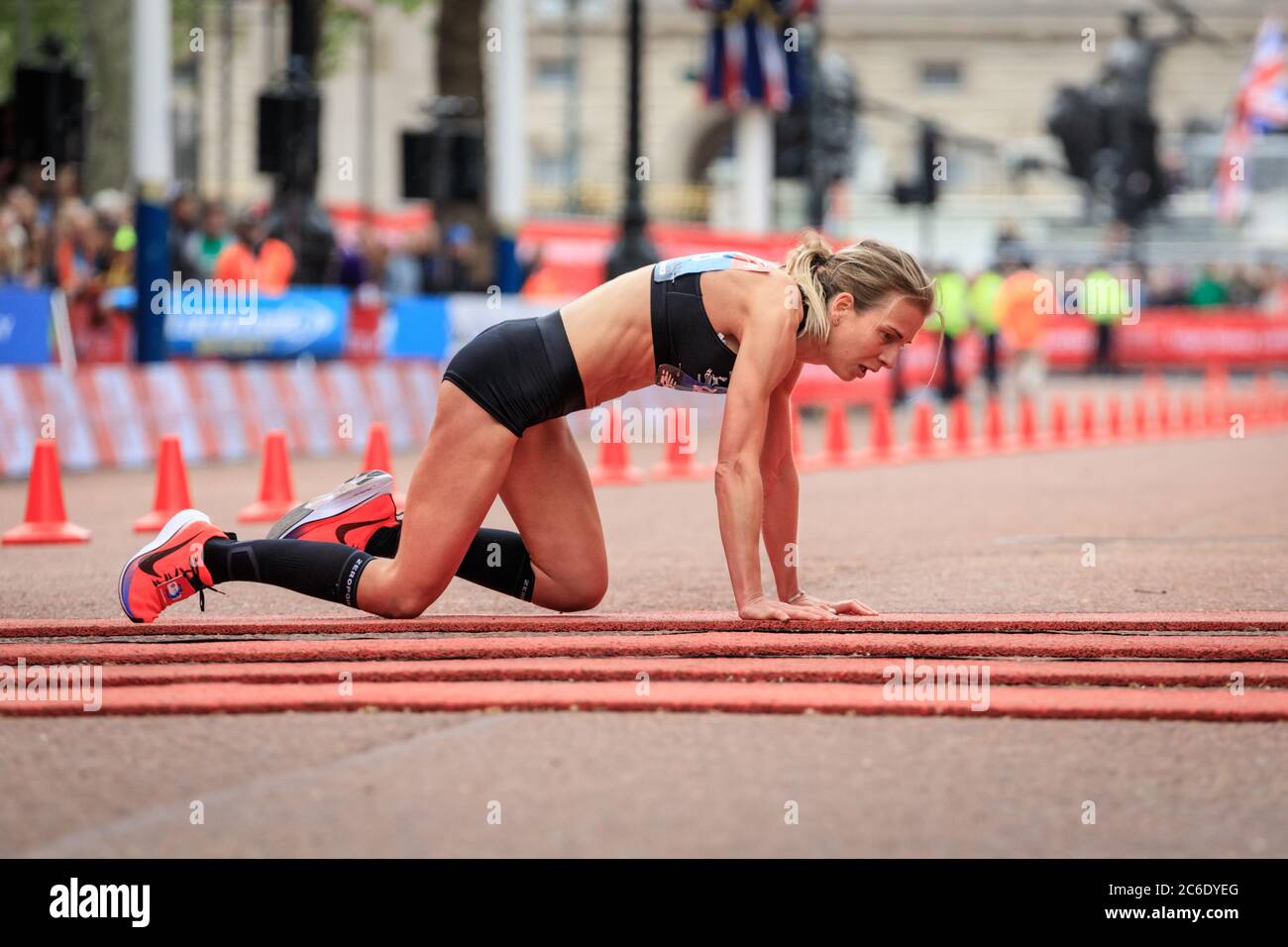 Female British elite runner Hayley Carruthers crawls over the finish line at Virgin Money London Marathon 2019, England, UK Stock Photo