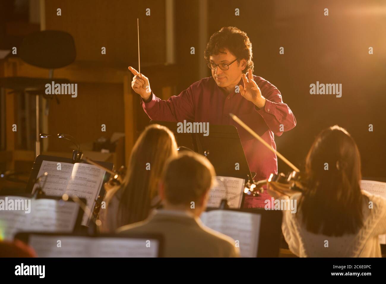 Conductor leading orchestra Stock Photo