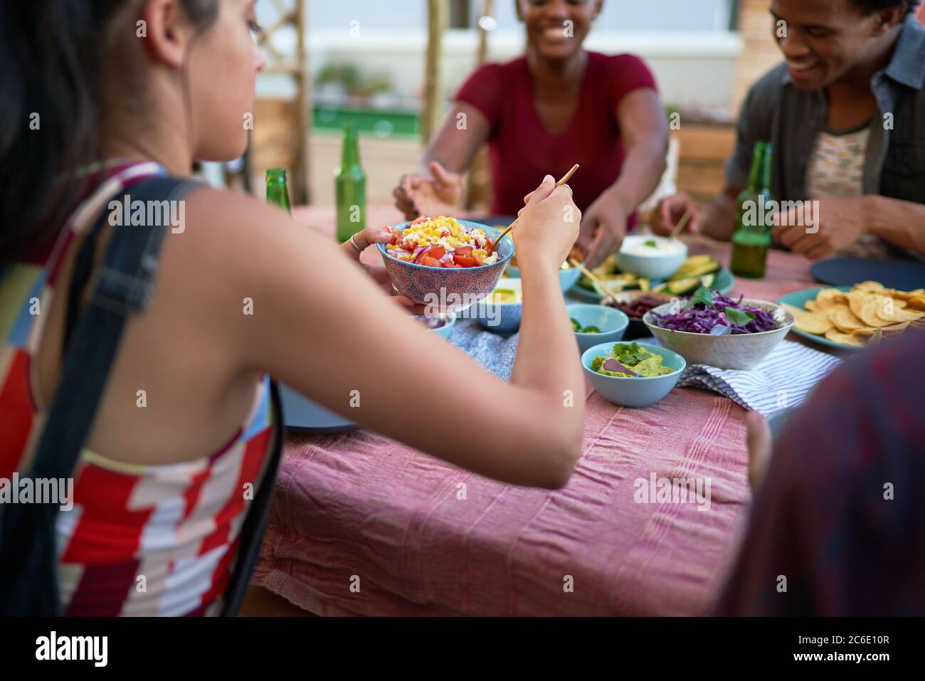 Young friends eating tacos at patio table Stock Photo