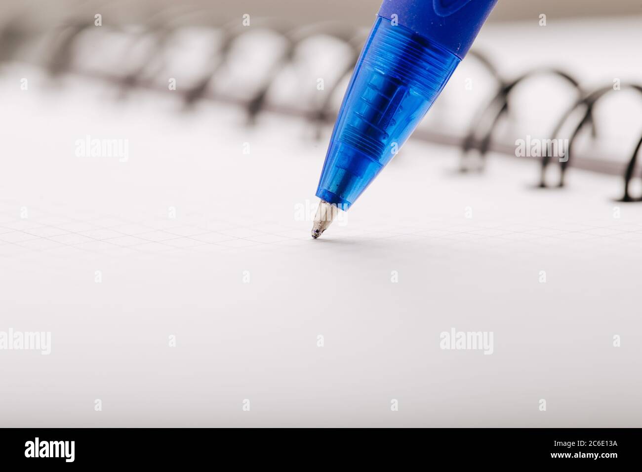Opened notepad in a cage with an automatic plastic ballpoint pen close-up. Stock Photo