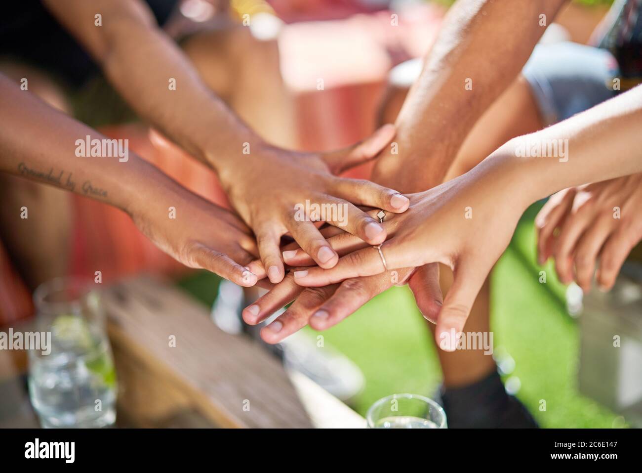 Close up friends joining hands in huddle Stock Photo