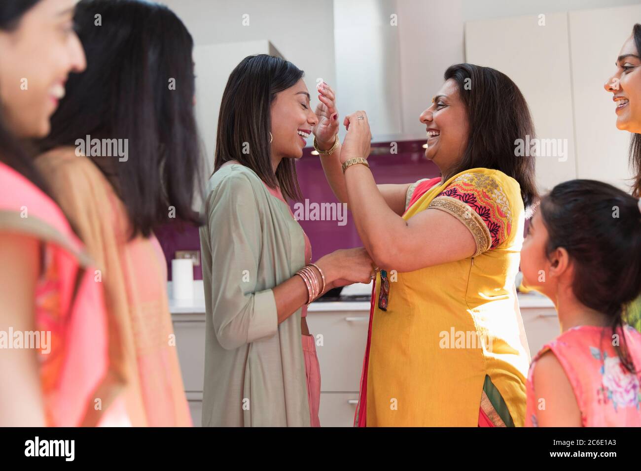 Smiling mother placing bind on forehead of daughter Stock Photo