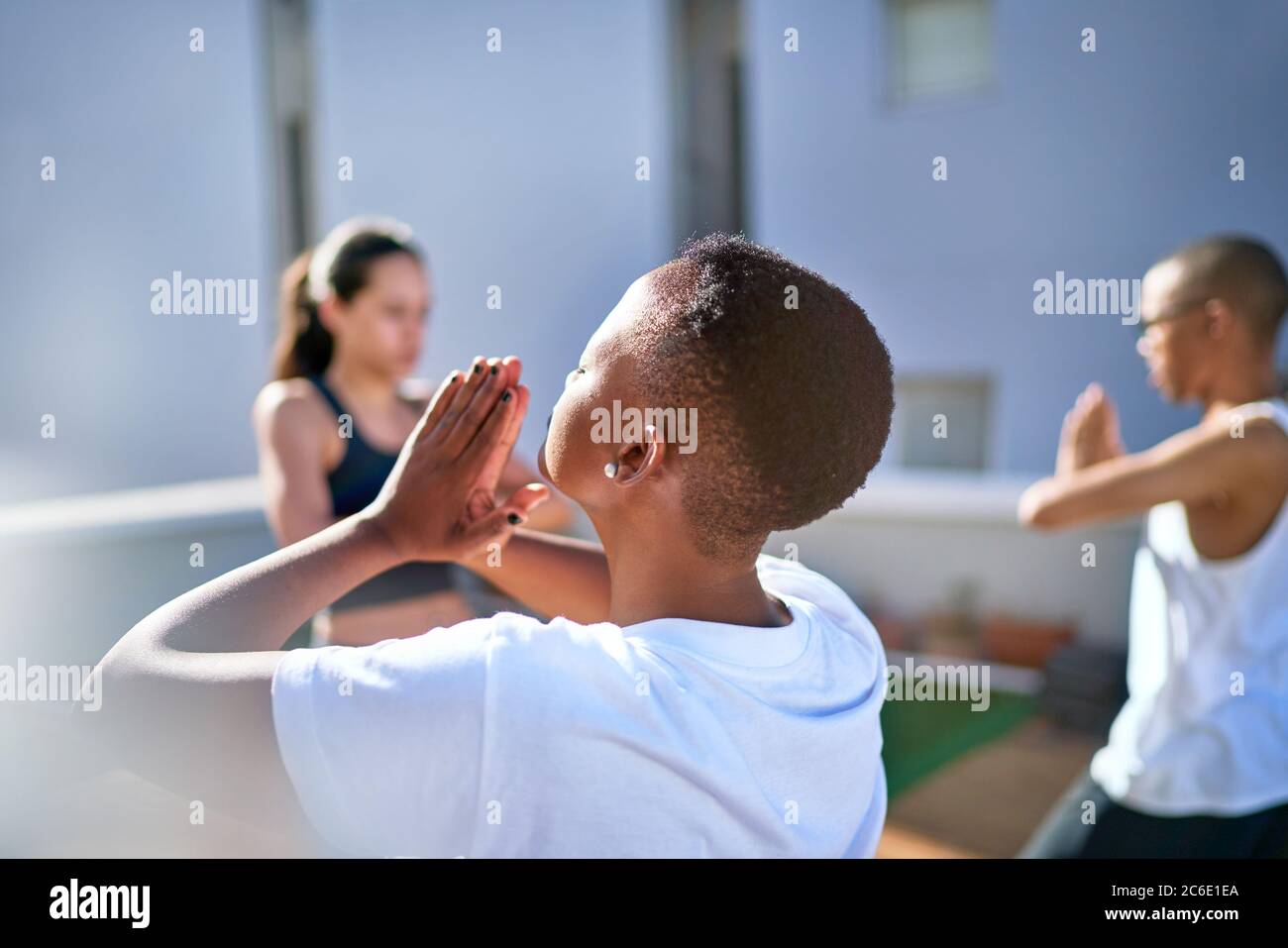 Serene young woman practicing yoga on sunny balcony Stock Photo