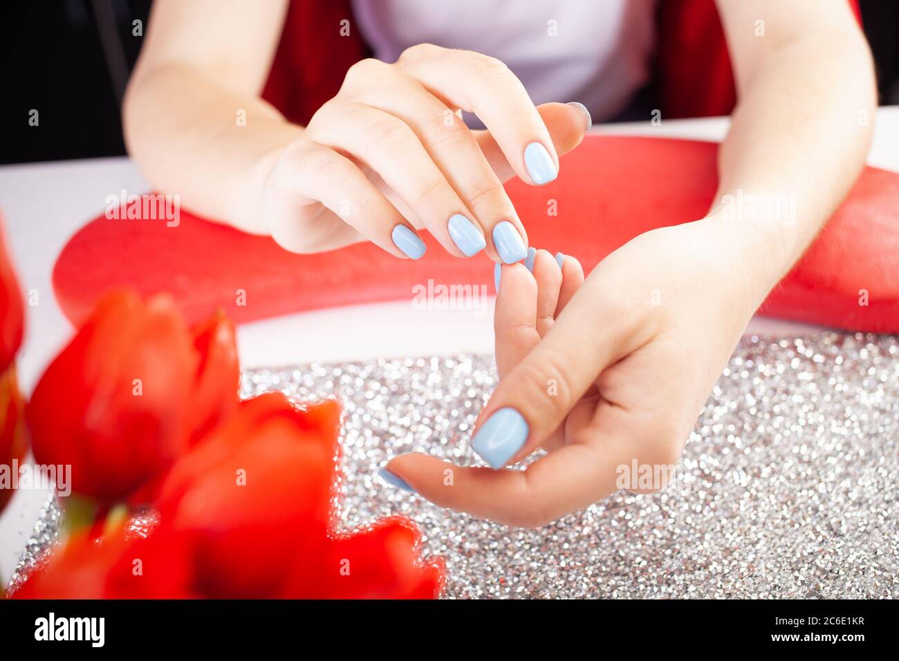 The final result of the manicure. Beautiful blue nails. The process of  manicure in a beauty salon. Salon in black, red, white Stock Photo - Alamy